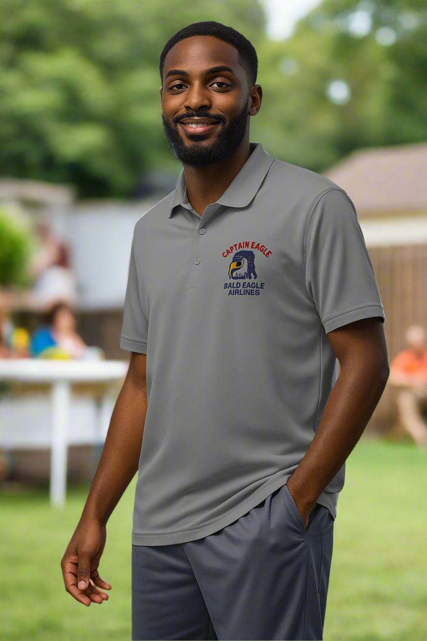 Man wearing a gray polo shirt with a logo outdoors