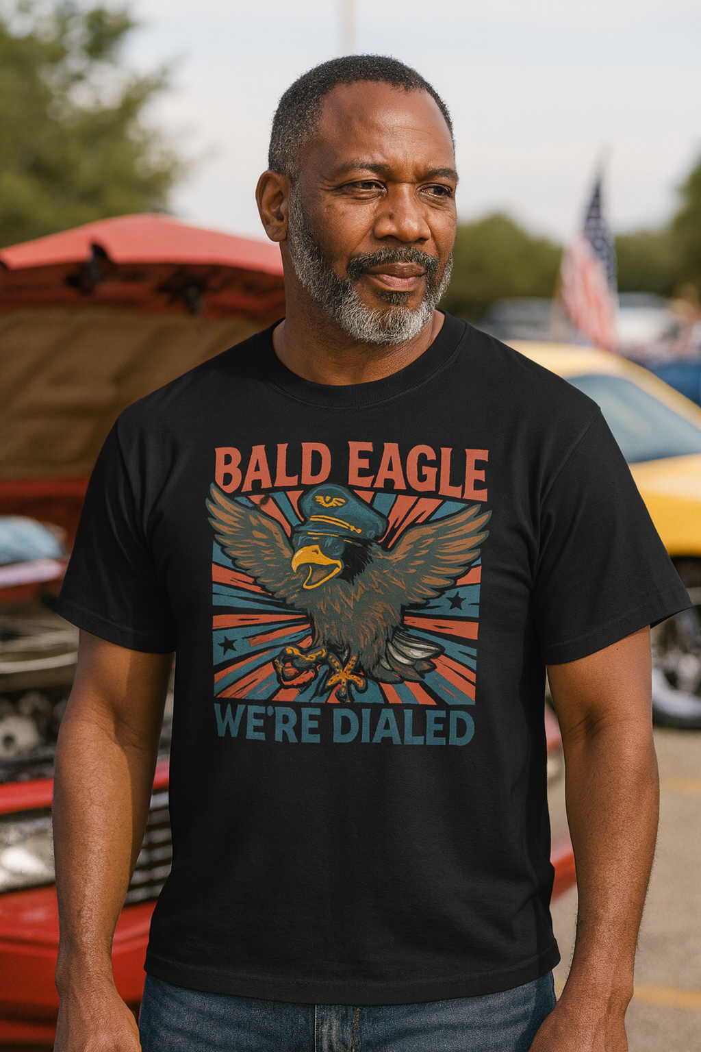 Man wearing a black t-shirt with an eagle graphic and text, standing outdoors.